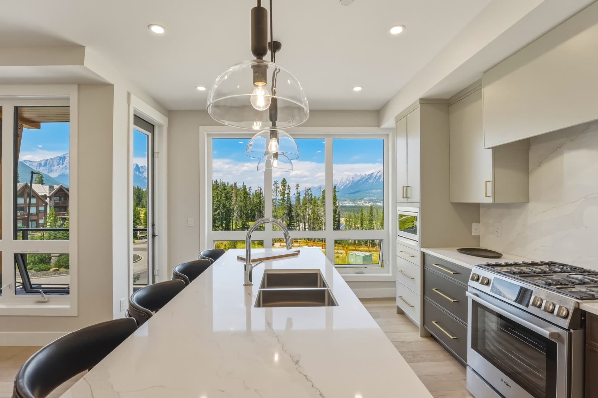 Kitchen island and gas range with forest and peak views